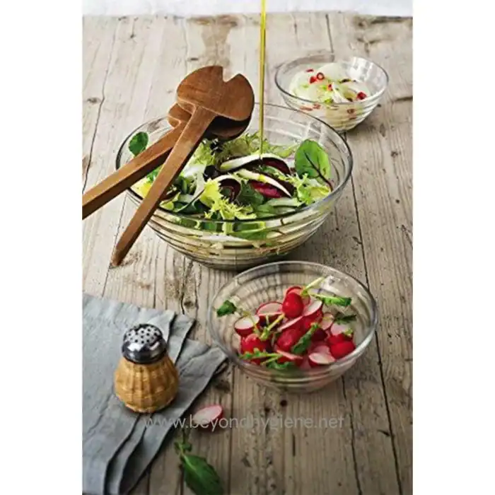 Fresh vegetable salads in glass bowls with radishes, leafy greens, and herbs, served on a rustic wooden table. Perfect for healthy eating and gourmet dining.