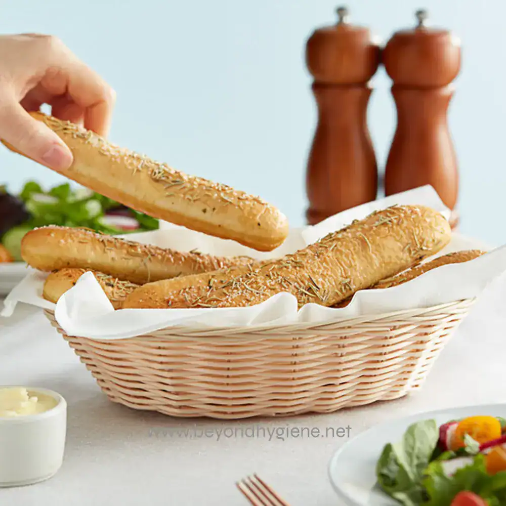 1 Crusty breadsticks with herbs in a woven basket, ready for serving at a restaurant or home. Perfect for snacks, appetizers, or accompanying meals, emphasizing hygiene and sanitation in food presentation.