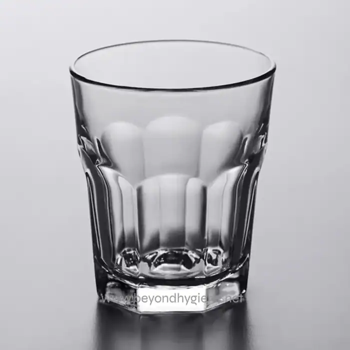 Sparkling clear glass tumbler on grey background, perfect for beverages, emphasizing hygiene and cleanliness.