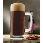 Rich amber beer in a glass mug with foam head, with pretzels on a rustic wooden surface and beer bottles in the background. Perfect for bar, pub, or brewery settings, emphasizing hygiene standards in beverage serving.