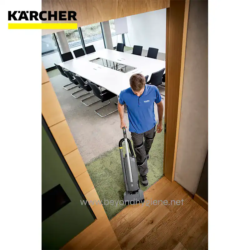BATTERY POWERED UPRIGHT BRUSH TYPE VAC ( (6) Deep cleaning service professional using commercial vacuum cleaner at office conference room for hygiene and sanitation.