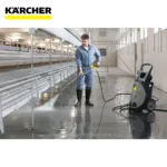 Spray cleaning in industrial warehouse using Karcher pressure washer for hygiene and sanitation.
