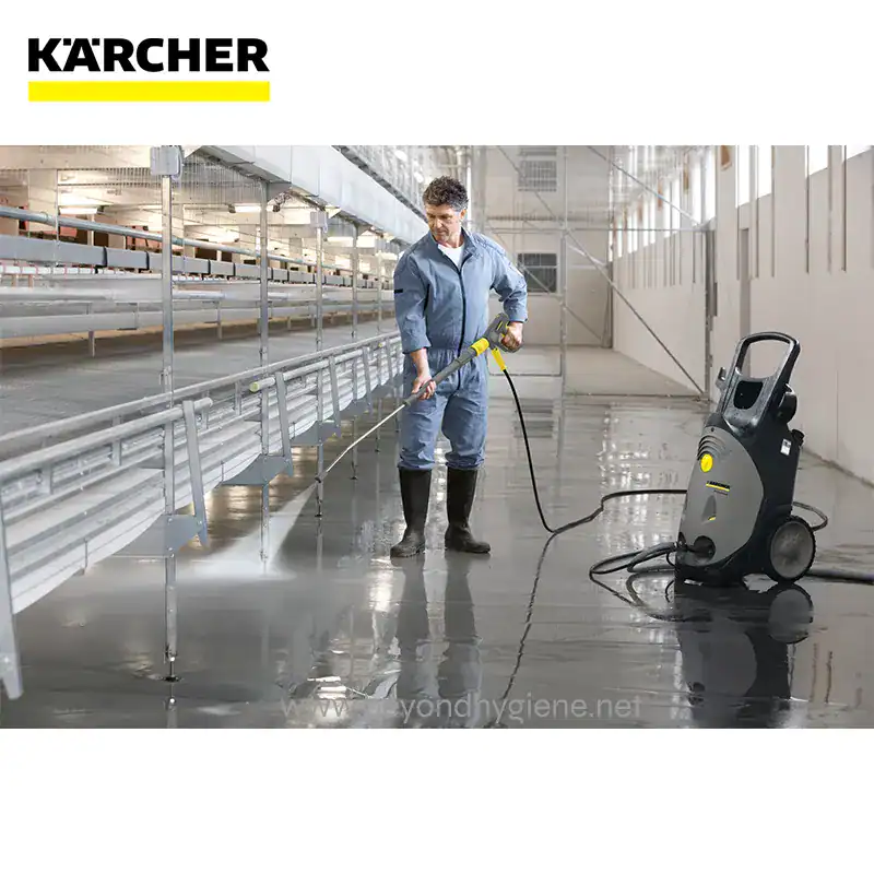 HIGH-PRESSURE WASHER HD 1025-4 S (2) Spray cleaning in industrial warehouse using Karcher pressure washer for hygiene and sanitation.