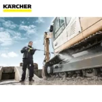Kärcher pressure washer cleaning heavy machinery at construction site in Asia.