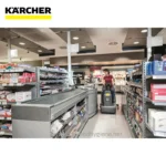 Karcher floor cleaning machine in retail store aisle, maintaining hygiene and cleanliness.