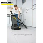 Kärcher commercial carpet and floor cleaner in use for professional hygiene and cleaning services in Asia. Woman operating heavy-duty cleaning equipment in a modern kitchen setting.