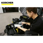 Kärcher floor cleaning equipment being serviced by technician outside showroom in Asia.