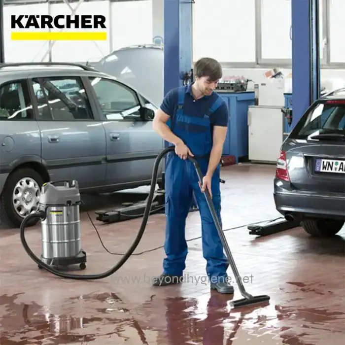 Professional car cleaning service at an auto workshop with industrial vacuum cleaner and hygienic flooring, ensuring spotless vehicle interiors.
