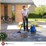 High-pressure water cleaner cleaning outdoor patio with garden hose during daytime.