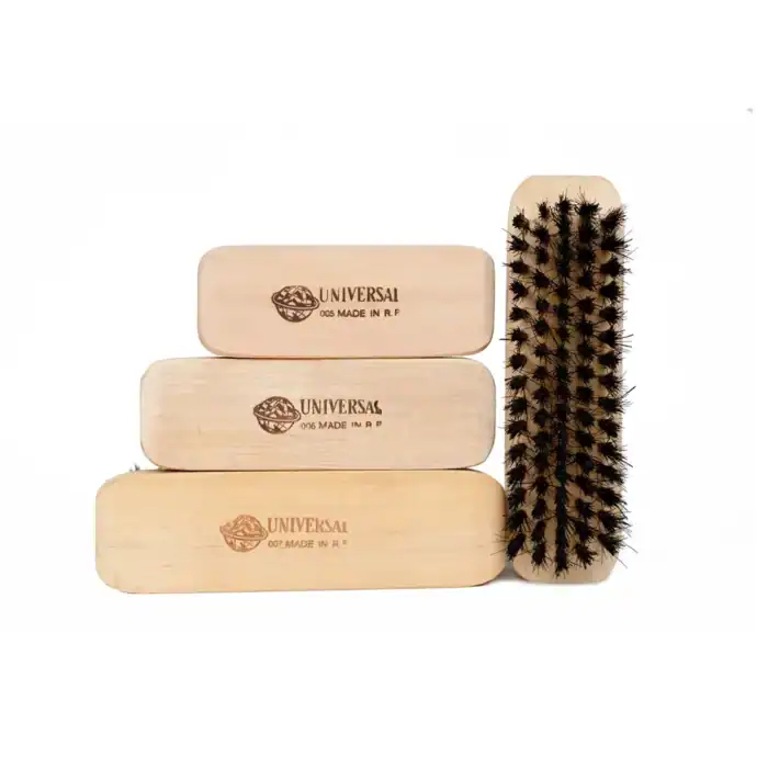 Natural wood shoe brushes with branded Universal logo for shoe cleaning and maintenance. Durable and eco-friendly shoe care tools for proper footwear hygiene.