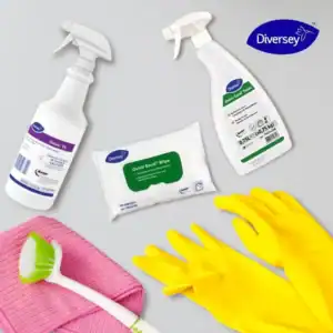 Disinfectant spray bottles, wipes, yellow rubber gloves, and cleaning cloths on a light gray background, emphasizing hygiene and cleaning supplies by Beyond Hygiene Asia.