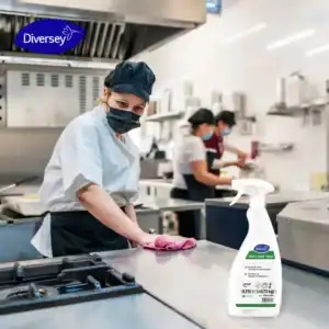 Disinfectant spray in commercial kitchen cleaning, with chef wiping surfaces to ensure hygiene, promoting food safety, sanitation products, and cleaning protocols.