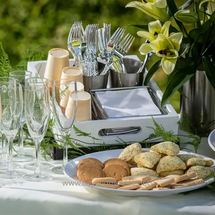 Elegant outdoor table setting with champagne flutes, disposable cups, cutlery, and floral decorations, emphasizing professional event hygiene and cleanliness for Beyond Hygiene Asia.