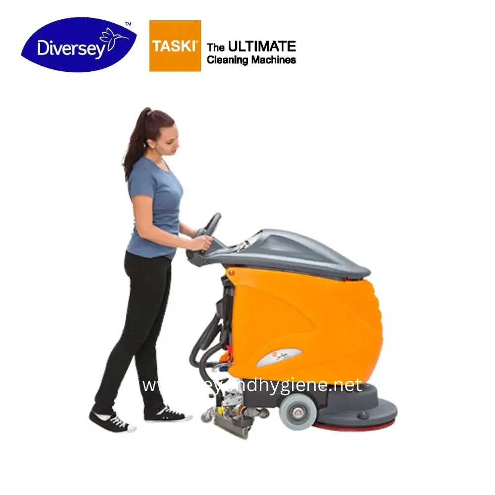 swingo 855B _ TASKI (3) Cleaning woman operating commercial floor scrubber machine for hygiene maintenance at public space.